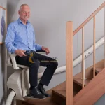 An old man using stairlift by Manafeth Mobility UAE