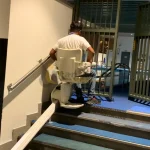 Stairlift with disabled man moving upward in Dubai
